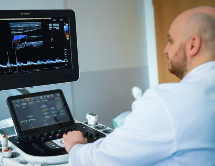 Bild zeigt Arzt des Neurozentrums Westfalen, der die Vitalwerte eines Patienten misst, der auf dem Bild nicht zu sehen ist