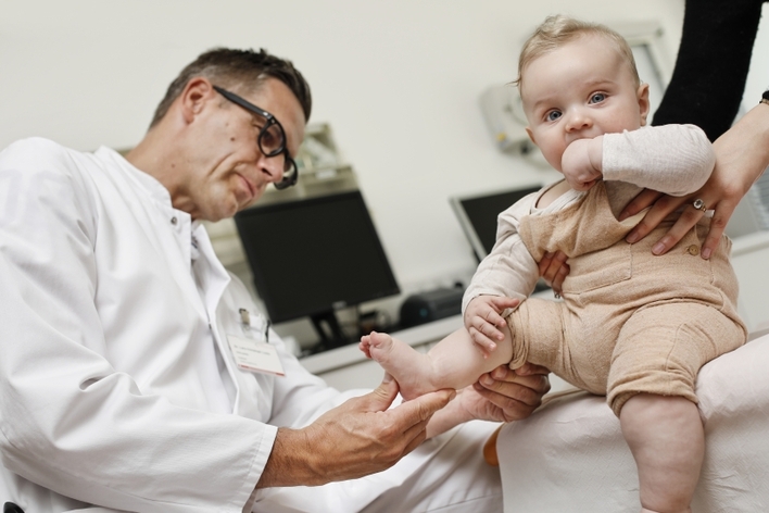 Ein Orthopäde untersucht den Fuß eines Babys.