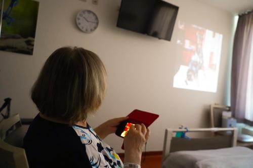 Johanna Schwierz schaut mittels eines Beamers ihre Bilder an der Wand an Palliativpatientin Johanna Schwierz
