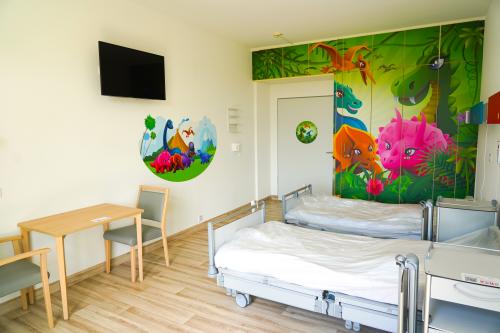 Die Patientenzimmer der Kinderklinik sind mit bunten Motiven gestaltet. Dieses Zimmer trägt das Motto "Dinosaurier". Patientenzimmer Kinderklinik