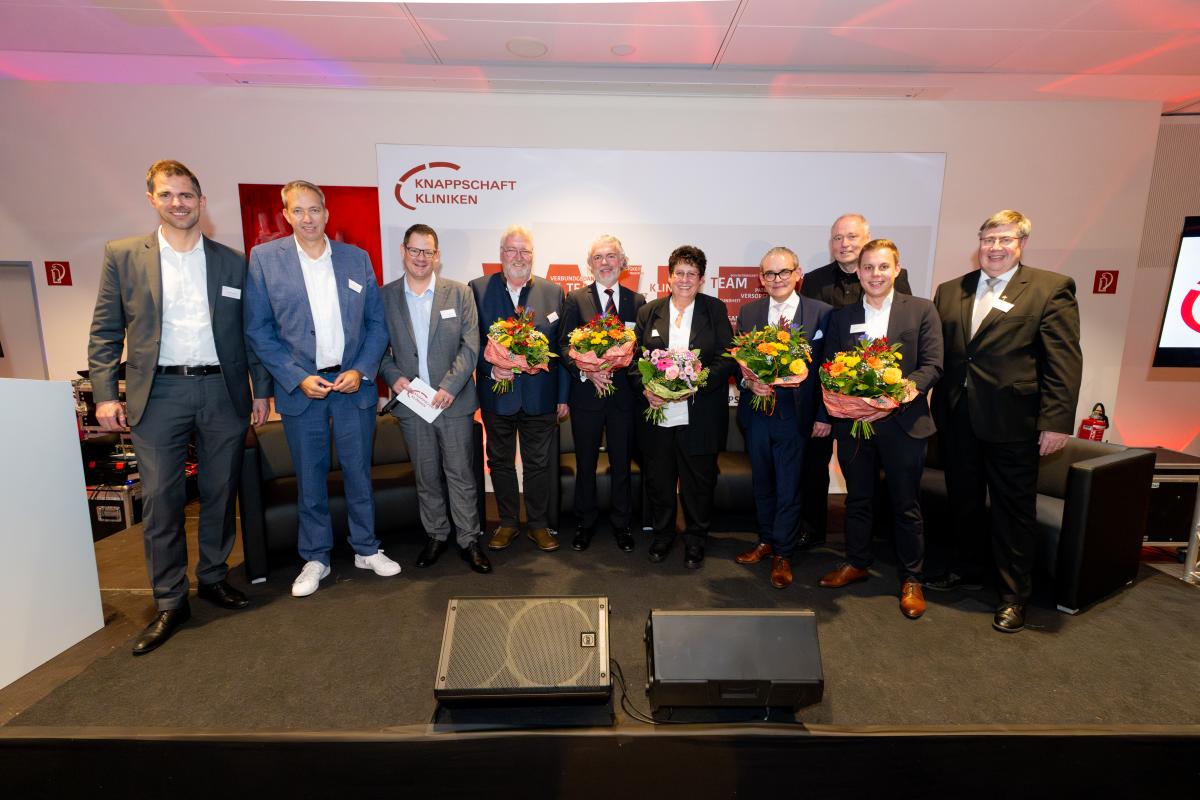 Freude über die erfolgreiche Fusion bei den Rednern des Abends: v.l. Dr. Philipp Silwedel (Bezirksregierung Münster), Andreas Schlüter (Erster Hauptgeschäftsführer (CEO) Knappschaft Kliniken GmbH), Björn Kasper (Ltg. Marketing und Kommunikation Knappschaft Kliniken Solutions GmbH), Heinz-Dieter Hoffmann (Aufsichtsrat), Prof. Dr. Hans-Christian Kolberg (Ärztl. Direktor Knappschaft Kliniken Marienhospital Bottrop), Christa Hermes (Pflegedirektorin Knappschaft Kliniken Bottrop), Stefan Grave und Matthias Wagner (Geschäftsführer Knappschaft Kliniken Bottrop GmbH), Thomas Göddertz (MdL, Erster stellv. Bürgermeister Stadt Bottrop), Propst Dr. Jürgen Cleve (St. Cyriakus Gemeinde). Auf dem Bild fehlt Michael Weberink (DRV Knappschaft-Bahn-See).
Fusionsfeier - Gruppenbild Redner