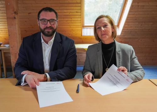 Der Kooperationsvertag wird unterzeichnet: Friedensdorf-Leiterin Birgit Stifter und Niklas Karwath, Geschäftsführer der Knappschaft Kliniken Vest GmbH signieren im Friedensdorf in Oberhausen.